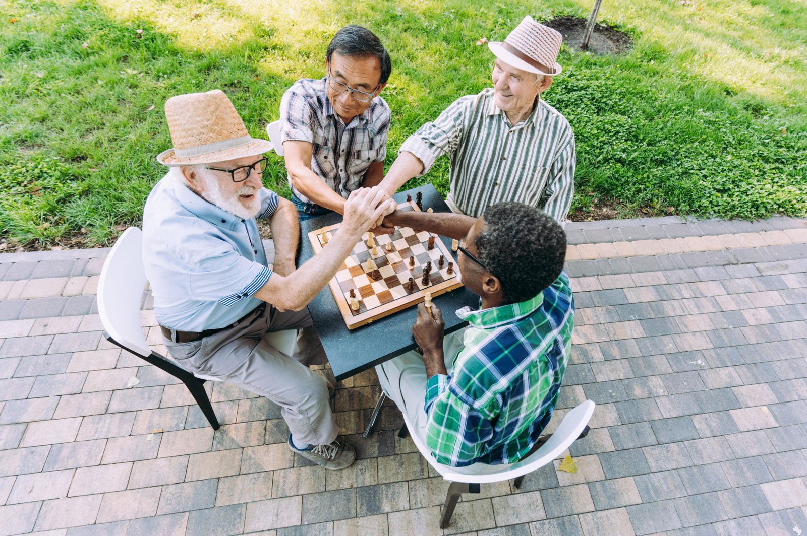 Group of senior friends playing chess game at the park. Lifestyle concepts about seniority and third age